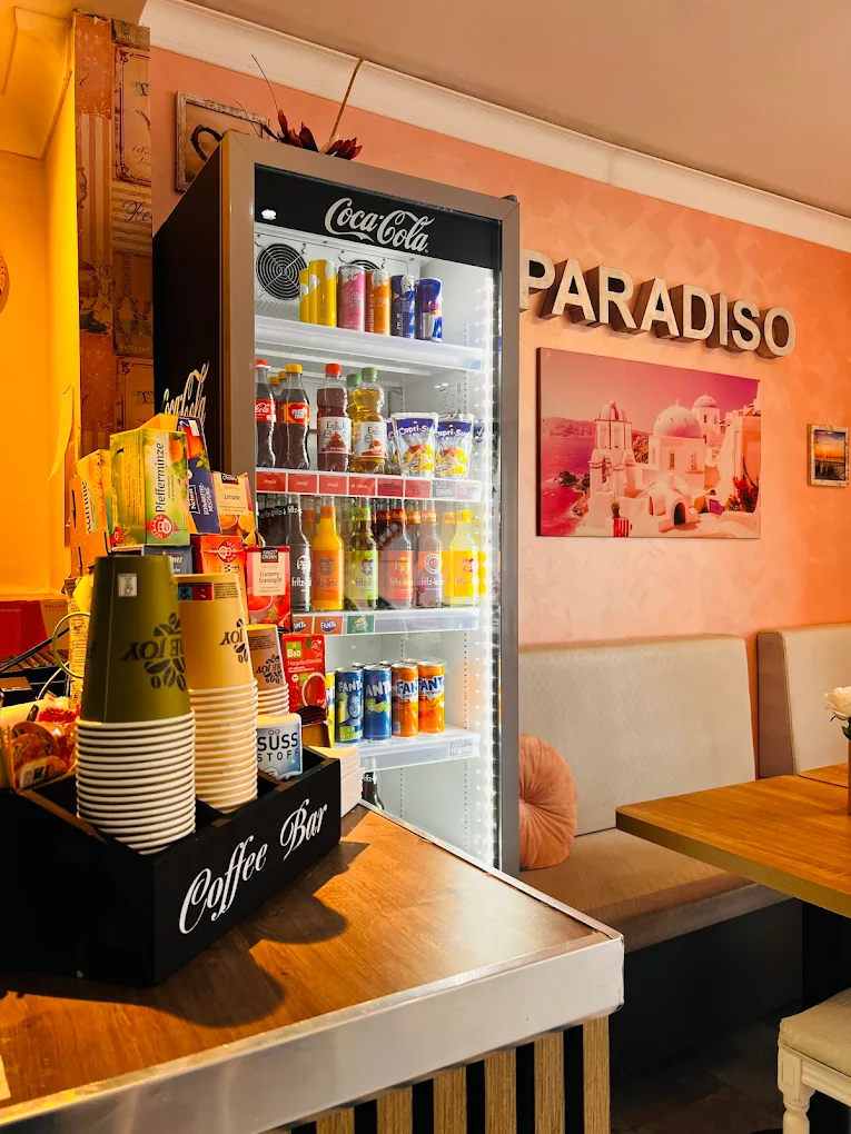 Coffee Bar mit Getränkekühlschrank und PARADISO-Schriftzug an der pfirsichfarbenen Wand